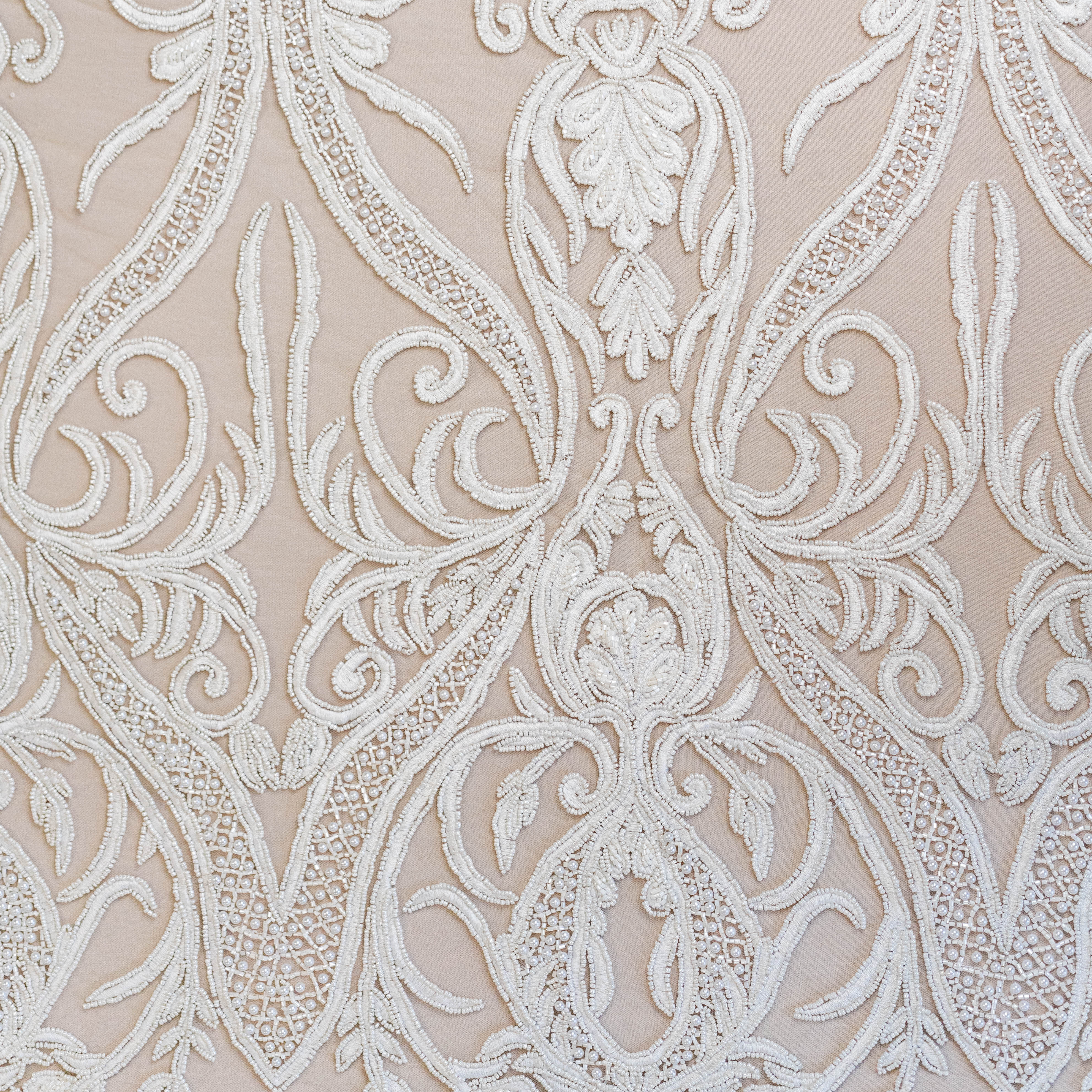Close-up of intricate white lace pattern on a beige background