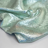 Close-up of metallic green and silver lurex jacquard fabric