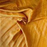 Turmeric Linen — mid-weight plain-weave linen with a slightly crisp handle that softens with wear, 100% linen, 135cm wide