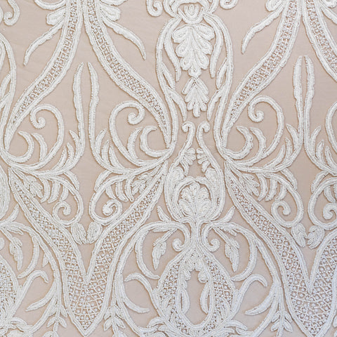 Close-up of intricate white lace pattern on a beige background