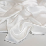 Close-up of textured hammered silk satin fabric in ivory colour, perfect for shirts, skirts and dresses, fashion and bridal