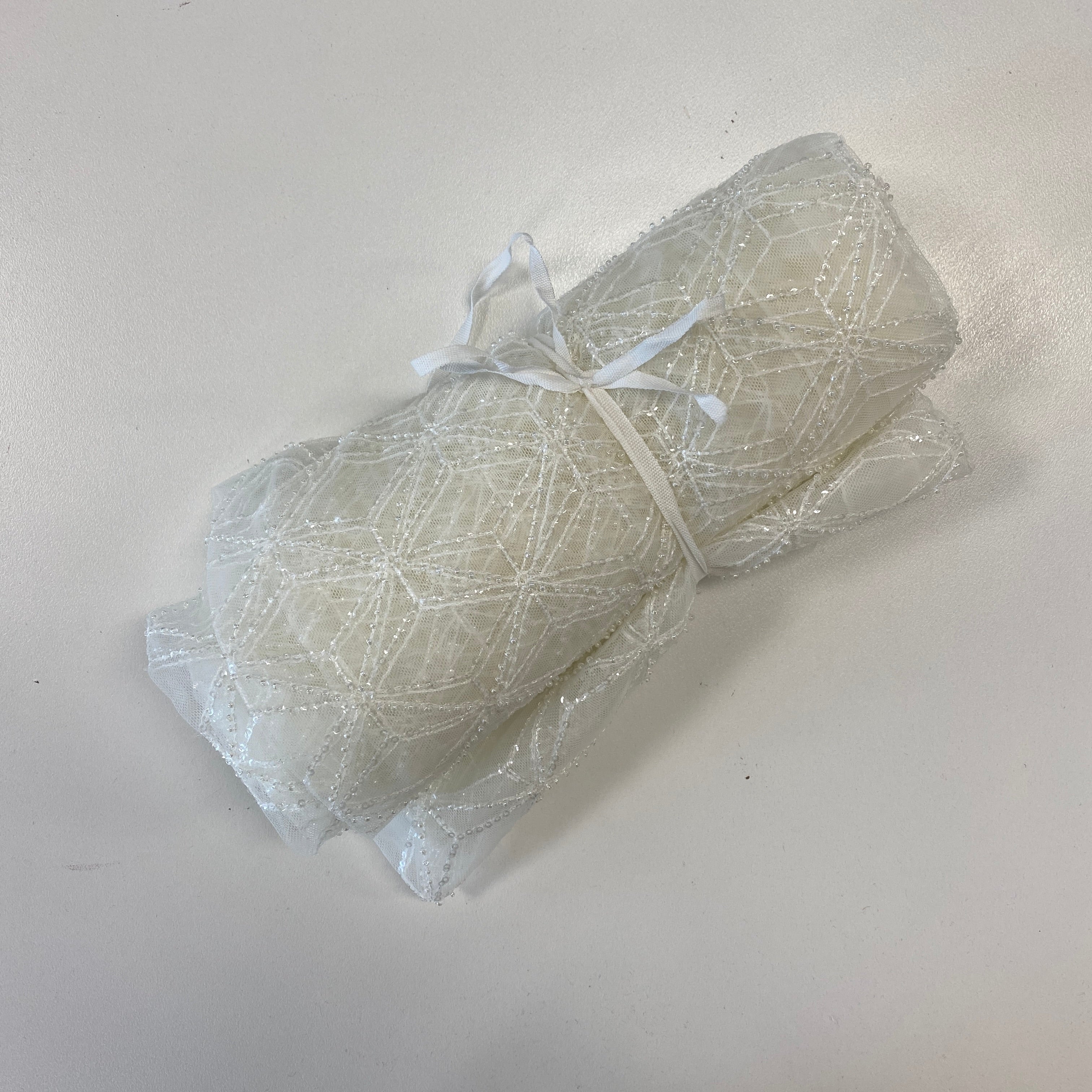 Ivory Beaded Tulle — featuring geometric motifs and hand-beading, 60% nylon 40% polyester, 130cm wide