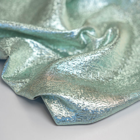 Close-up of metallic green and silver lurex jacquard fabric