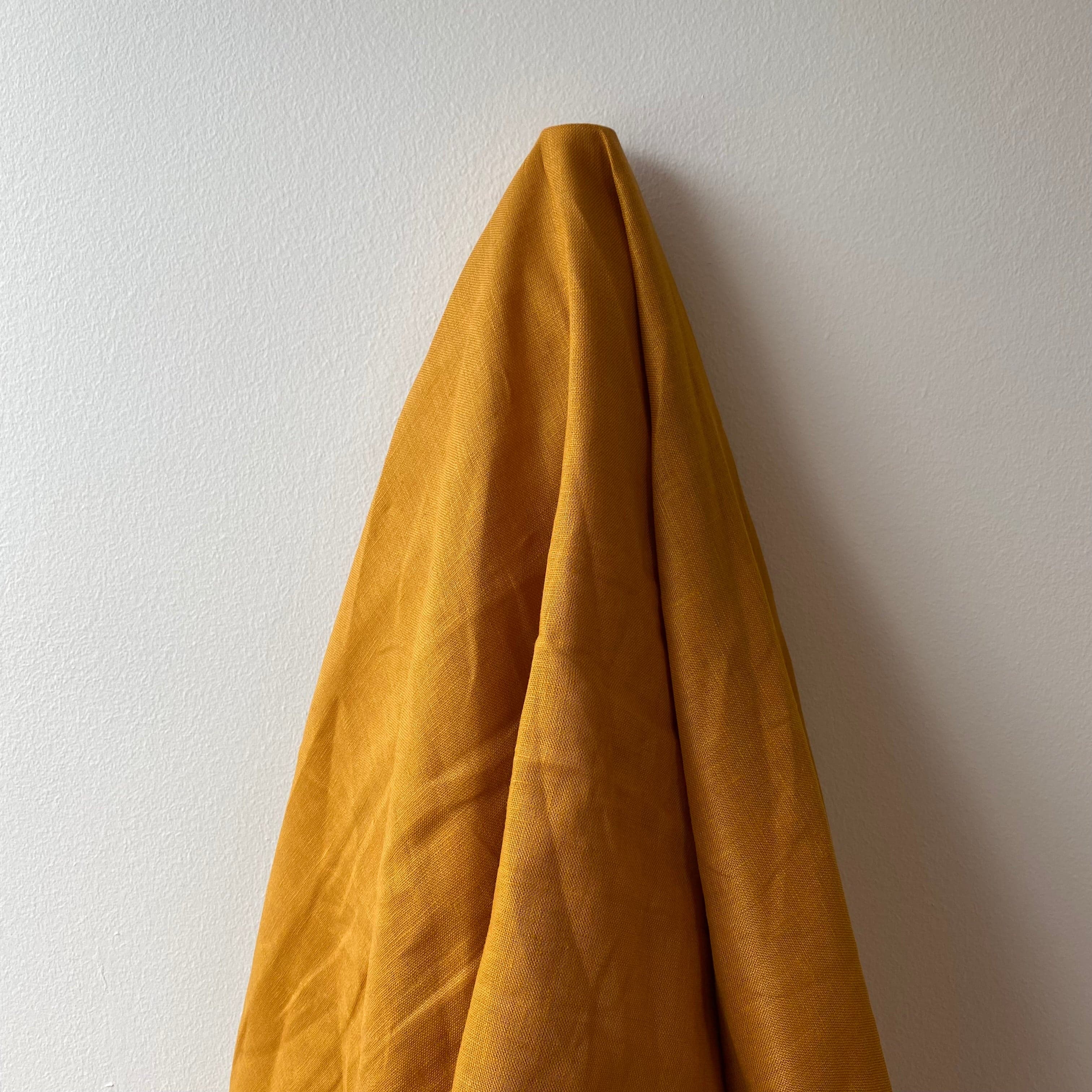 Turmeric Linen — mid-weight plain-weave linen with a slightly crisp handle that softens with wear, 100% linen, 135cm wide