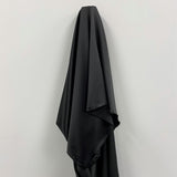 Black Stretch Polyester Lining — lightweight with a satin finish, matte reverse and gentle stretch, in polyester